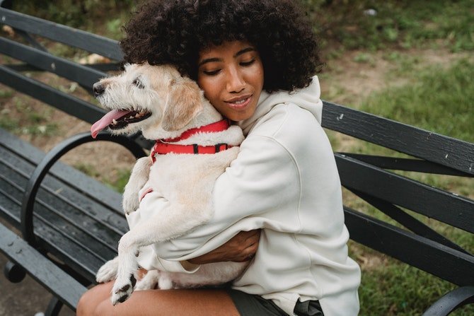Happy woman cuddling dog