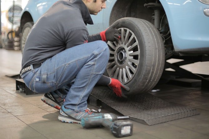 Man fitting tyres in garage