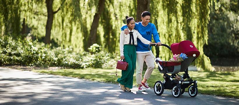 Young couple walking through the park with their Bugaboo stroller
