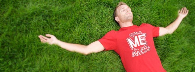 Man laying grass wearing slogan tee