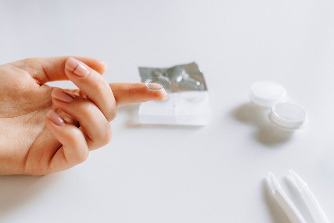 Woman putting contact lens in