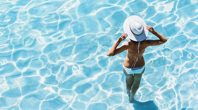 Woman standing in swimming pool on holiday