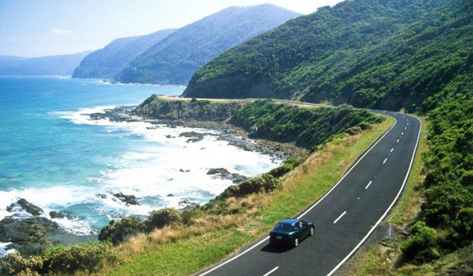Car driving on road next to sea