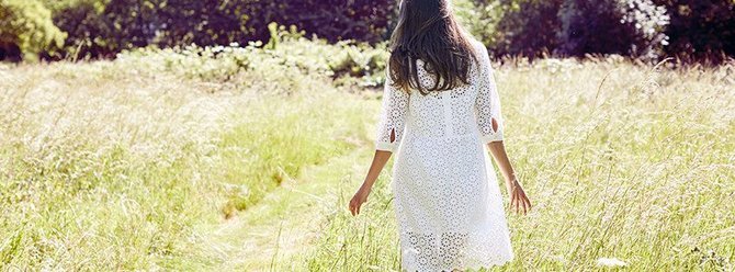 Thought discount codes banner - woman walking through fields wearing Thought dress